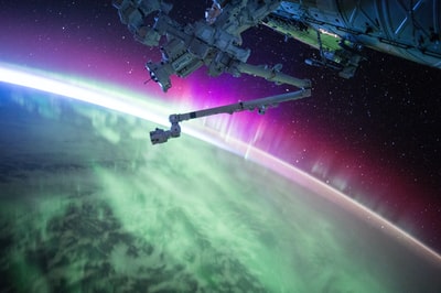 灰色空间卫星下紫绿极光束的摄影